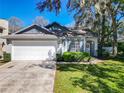 Charming home with manicured lawn, two-car garage, and welcoming front entrance at 1525 Oakwood Ct, Apopka, FL 32703