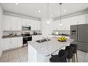 Modern kitchen featuring granite countertops, stainless steel appliances and island with seating at 1676 Blue Lagoon Cir, Mascotte, FL 34753