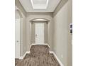 Inviting hallway with archways, wood-look tile flooring, a skylight, and neutral paint at 1740 Standing Rock Cir, Oakland, FL 34787