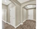 Hallway with archways and wood-look tile flooring leads to the rest of the home at 1740 Standing Rock Cir, Oakland, FL 34787