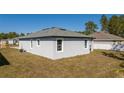 Rear view of the home with a well-maintained yard and classic architectural design at 1857 Manitoba Ct, Poinciana, FL 34759