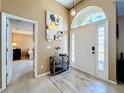 Inviting foyer featuring a large archway to the main bedroom, a decorative table, and light wood floors at 2253 Lake Pointe Cir, Leesburg, FL 34748