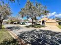 Inviting street view showcasing a well-maintained home, mature trees, and a neatly landscaped front yard at 2707 Barnsley Ln, Kissimmee, FL 34744