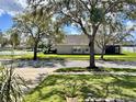 A home with a spacious yard visible from the street, showcasing curb appeal in a tranquil residential setting at 2707 Barnsley Ln, Kissimmee, FL 34744