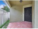 A tiled front entryway featuring a black front door and a white lattice fence at 3288 Brewster Dr, Kissimmee, FL 34743