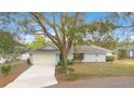 A well-maintained single-story home features a two-car garage and a neatly landscaped front yard with mature trees at 4029 Cool Water Ct, Winter Park, FL 32792