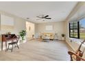 Bright living room featuring neutral paint, laminate flooring, a ceiling fan, and a large bay window at 4029 Cool Water Ct, Winter Park, FL 32792