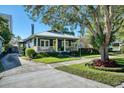 A picturesque view of the blue home showcasing its landscaped yard, front porch, and inviting curb appeal at 428 Highland Ave, Orlando, FL 32801