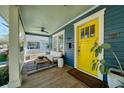 Inviting front porch featuring comfortable seating, a ceiling fan, and a vibrant yellow front door at 428 Highland Ave, Orlando, FL 32801