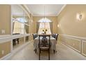 Bright dining room featuring a large window and an elegant chandelier at 4414 Azure Isle Way, Kissimmee, FL 34744