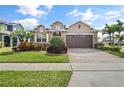 Beautiful two-story home featuring a manicured lawn and colorful landscaping at 4414 Azure Isle Way, Kissimmee, FL 34744