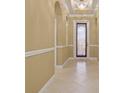 Welcoming hallway with decorative trim and ceramic tile flooring, leading to the front door at 4414 Azure Isle Way, Kissimmee, FL 34744