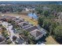 Aerial view of homes backing onto a pond with lush green trees around the community at 601 Orange Cosmos Blvd, Davenport, FL 33837