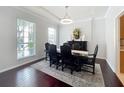 Elegant dining room featuring a dark wood table, chandelier, and ample natural light at 6244 Little Lake Sawyer Dr, Windermere, FL 34786