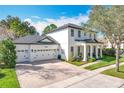 Elegant home with a three-car garage, brick driveway, lush lawn, and meticulously maintained landscaping at 6244 Little Lake Sawyer Dr, Windermere, FL 34786