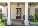 Inviting front porch with stylish decor, including potted plants and comfortable seating at 6244 Little Lake Sawyer Dr, Windermere, FL 34786