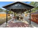 Outdoor dining under the custom pergola in a cozy backyard setting, perfect for entertaining at 6872 Compass Ct, Orlando, FL 32810