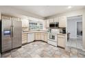 Bright kitchen with white cabinets, stainless steel appliances, and checkerboard tile flooring for a classic look at 101 Ludlow Dr, Longwood, FL 32779