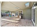 This covered patio features brick flooring, a skylit ceiling, and a stainless steel grill for outdoor cooking at 101 Ludlow Dr, Longwood, FL 32779