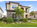 Beautiful two-story house featuring stone accents, stucco exterior, and a well-kept lawn with manicured landscaping at 10236 Beechwood Ln, Orlando, FL 32832