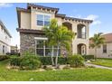 A lovely two-story home exhibits stone detailing with a lush front lawn and landscaped garden at 10236 Beechwood Ln, Orlando, FL 32832