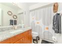 Modern bathroom with granite countertop, stylish shower curtain, and hexagon wall art at 12240 Huntsman Ln, Orlando, FL 32826