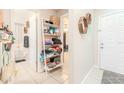 Bright hallway featuring decorative wall shelves, tiled flooring and bathroom entrance at 12240 Huntsman Ln, Orlando, FL 32826