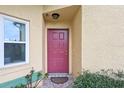 Close-up of the red front door with a welcoming doormat and a well-kept exterior at 13469 Texas Woods Cir, Orlando, FL 32824