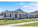 Charming single-story home features a manicured lawn, two-car garage, and welcoming front entrance with decorative accents at 2168 Continental St, St Cloud, FL 34769