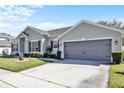 This gray home features a two car garage and well-maintained landscaping, offering both convenience and curb appeal at 2168 Continental St, St Cloud, FL 34769