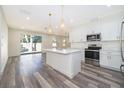 Modern kitchen with white cabinets, stainless steel appliances, an island, and contemporary pendant lighting at 248 Robin Rd, Altamonte Springs, FL 32701