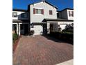 Townhouse showcasing a well-manicured lawn and a brick paved driveway at 272 Cedar Bark Ln, Sanford, FL 32771