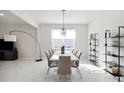 Dining room with a modern chandelier hanging over a white dining table with seating for eight at 2729 Timbergrove St, St Cloud, FL 34771