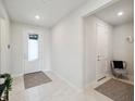 Bright foyer featuring tile floors, white walls, and a decorative front door with glass at 2729 Timbergrove St, St Cloud, FL 34771