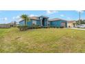 Blue, single story home with a well manicured lawn and a palm tree at 2851 Stonewood Cir, Lakeland, FL 33810