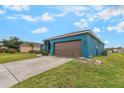 Side view of blue single story home with an attached two car garage at 2851 Stonewood Cir, Lakeland, FL 33810