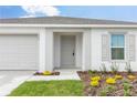 Welcoming home exterior showcasing a well-manicured lawn, a charming front door and an attached garage at 304 Towns Cir, Haines City, FL 33844