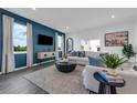 Comfortable living room features a blue accent wall, modern decor, and large windows at 3489 Salvia Ct, Tavares, FL 32778