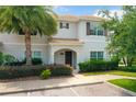 Inviting two-story townhome with a tile roof, front porch, and well-maintained landscaping at 4865 Clock Tower Dr, Kissimmee, FL 34746