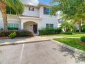 Beautiful two-story home with tile roof, mature landscaping, and sidewalk leading to the entrance at 4865 Clock Tower Dr, Kissimmee, FL 34746