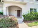 Welcoming front entrance with a covered porch, tiled walkway, and lush shrubbery at 4865 Clock Tower Dr, Kissimmee, FL 34746