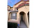 Charming townhouse showcasing a warm exterior paint, red tile roof, and classic archway entrance for appeal at 5290 Paradise Cay Circle, Kissimmee, FL 34746