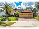 Charming tan two-story home with a three-car garage, lush lawn, and mature landscaping at 8606 Terrace Pines Ct, Orlando, FL 32836