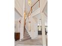 Bright foyer with staircase features neutral paint and carpet, wood railing, and high ceilings at 8606 Terrace Pines Ct, Orlando, FL 32836