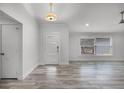 Bright living room featuring wood-look tile flooring, a modern light fixture, and a large window that provides natural light at 8908 Turnberry Ct, Orlando, FL 32819