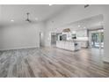 Spacious open-concept floor plan showcasing wood-look tile flooring, a modern kitchen with an island, and ample natural light at 8908 Turnberry Ct, Orlando, FL 32819