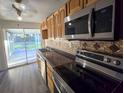 Well-lit kitchen featuring stainless steel appliances, custom backsplash, and a sliding glass door to the backyard at 11618 Churchill St, Orlando, FL 32817
