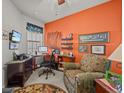 Comfortable home office featuring a large window, desk, and cozy armchair at 1206 Bella Cara Ct, Davenport, FL 33896