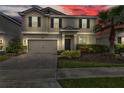 Charming two-story home with neutral stucco, dark shutters, brick driveway and well maintained landscaping at 1616 Oak Blossom Dr, Davenport, FL 33837