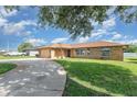 Beautiful brick home with a circular driveway and lush green lawn at 1644 Piccadilly Dr, Daytona Beach, FL 32117
